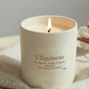 Bougie naturelle L'Équinoxe signée Bain de Cire, parfum feuille de figuier et patchouli, design minimaliste et flamme douce sur fond naturel.